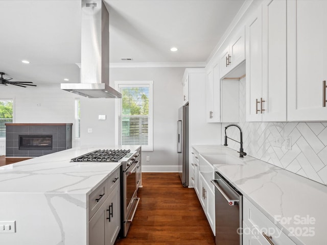 kitchen with premium appliances, white cabinetry, plenty of natural light, and island exhaust hood