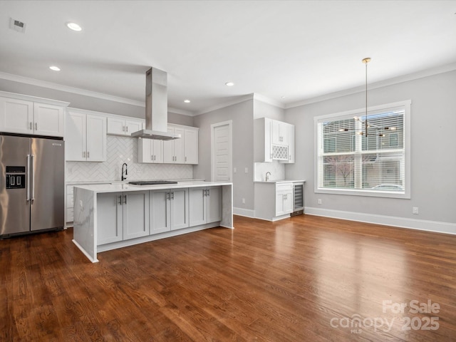 kitchen with visible vents, island exhaust hood, light countertops, decorative backsplash, and high end fridge