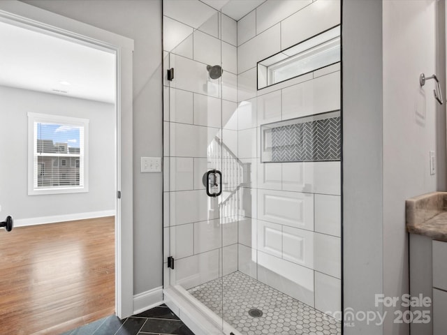 full bath featuring baseboards and a shower stall