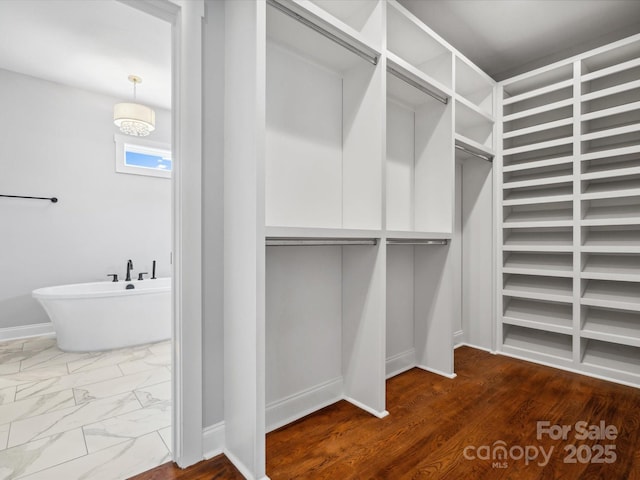 spacious closet featuring marble finish floor