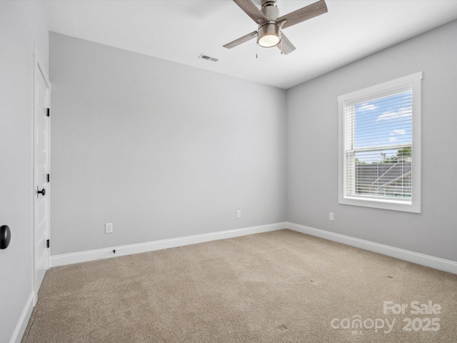 empty room with visible vents, baseboards, a ceiling fan, and light colored carpet