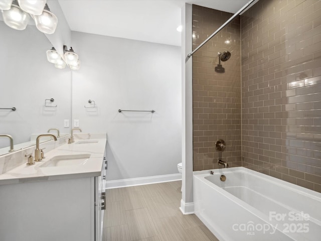 full bathroom featuring  shower combination, toilet, a sink, tile patterned floors, and baseboards