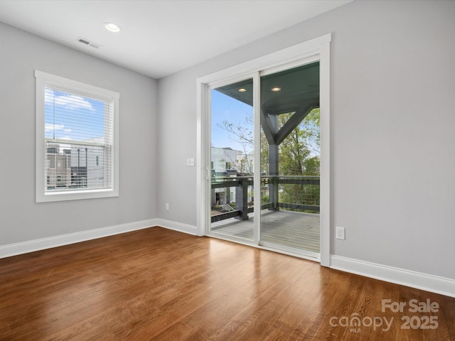 empty room with recessed lighting, visible vents, baseboards, and wood finished floors