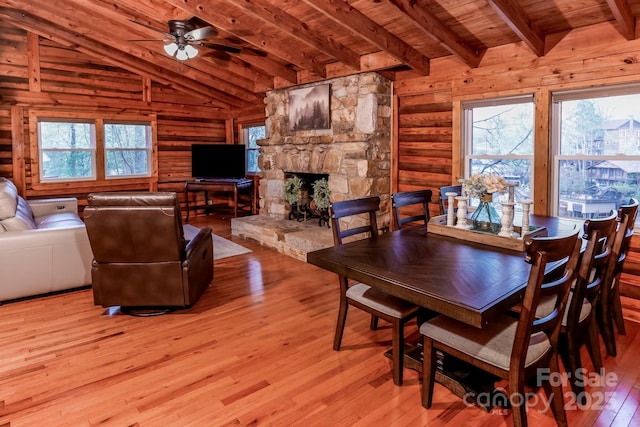 dining area featuring vaulted ceiling with beams, log walls, a ceiling fan, and wood ceiling