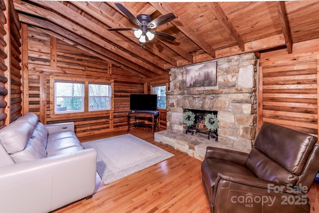 living room featuring vaulted ceiling with beams, wooden ceiling, and rustic walls