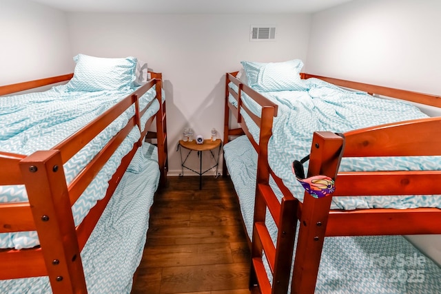 bedroom featuring visible vents, baseboards, and wood finished floors