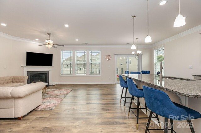interior space featuring a sink, crown molding, a ceiling fan, and a healthy amount of sunlight