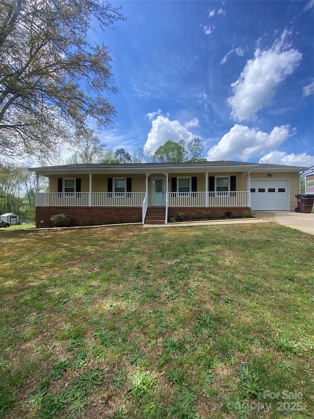 ranch-style home featuring an attached garage, concrete driveway, a front yard, and a porch