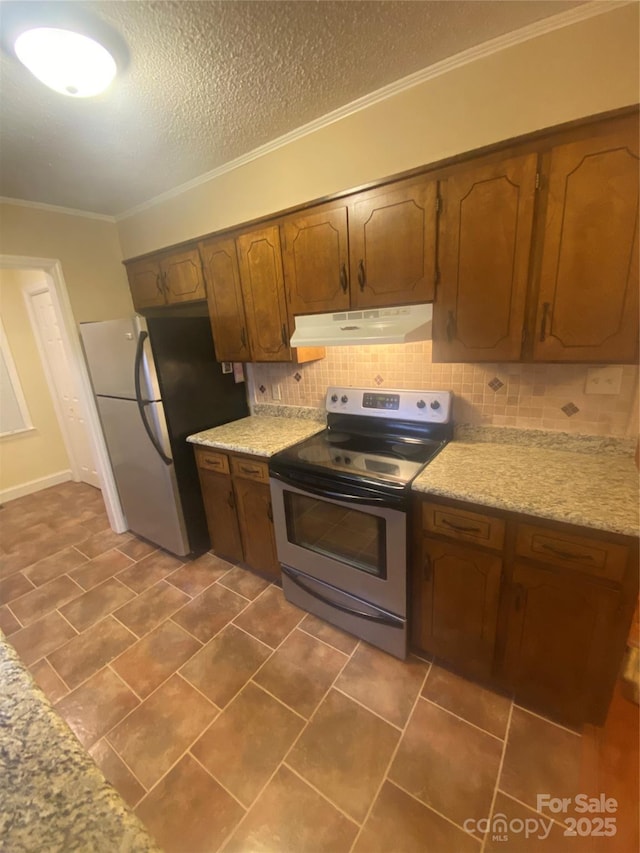 kitchen with ornamental molding, light countertops, under cabinet range hood, stainless steel appliances, and decorative backsplash