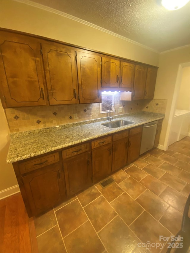 kitchen with tasteful backsplash, ornamental molding, brown cabinets, dishwasher, and a sink