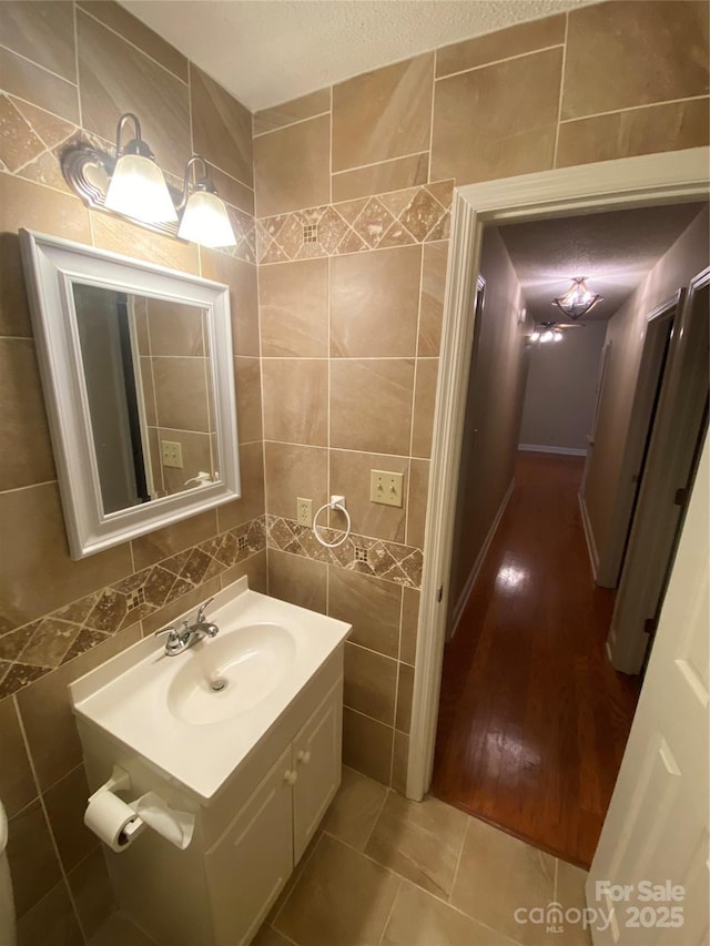 bathroom with tile patterned flooring, vanity, and tile walls