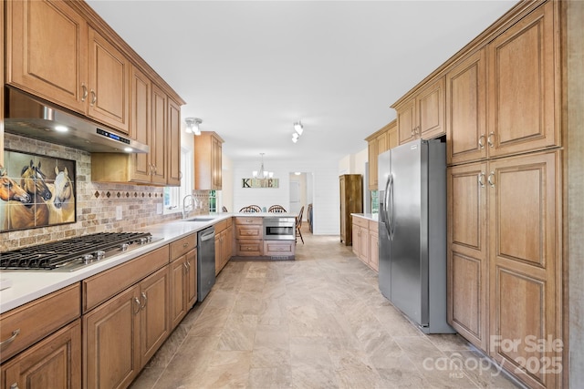 4896 Pageland Hwy, Lancaster, SC 29720 - kitchen featuring appliances with stainless steel finishes, under cabinet range hood, tasteful backsplash, and brown cabinetry