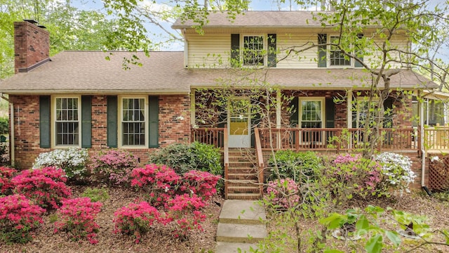 147 Spring Shore Rd, Statesville, NC 28677 - traditional-style home with brick siding, a chimney, a shingled roof, and covered porch