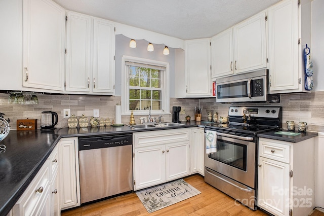 147 Spring Shore Rd, Statesville, NC 28677 - kitchen featuring dark countertops, white cabinetry, a sink, and appliances with stainless steel finishes