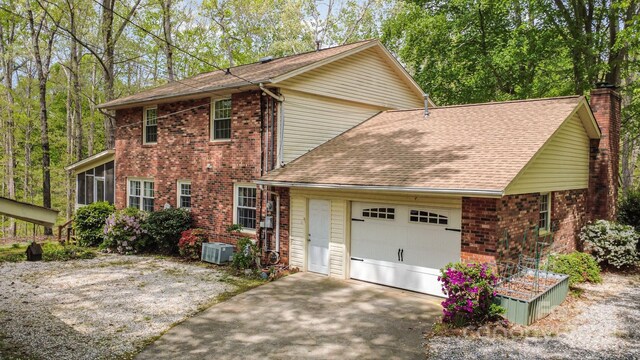 147 Spring Shore Rd, Statesville, NC 28677 - view of front of house with a garage, a chimney, concrete driveway, brick siding, and roof with shingles