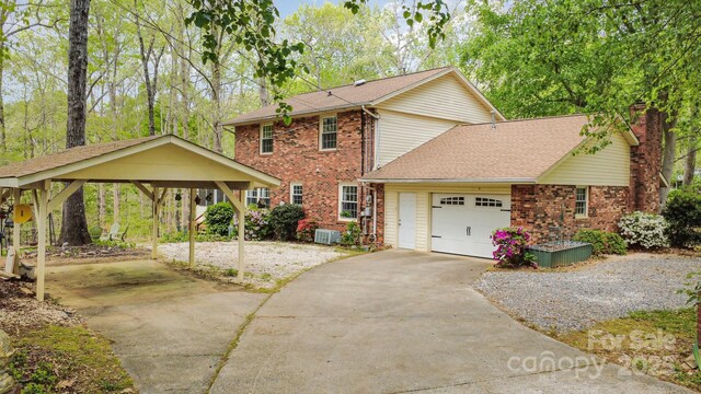 147 Spring Shore Rd, Statesville, NC 28677 - view of front of home featuring concrete driveway, a chimney, an attached garage, brick siding, and central AC unit