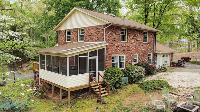 147 Spring Shore Rd, Statesville, NC 28677 - rear view of house with concrete driveway, brick siding, a sunroom, and a garage