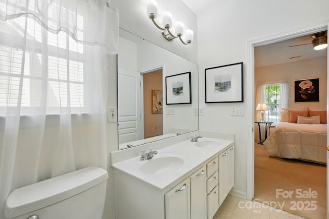 full bathroom featuring a sink, ensuite bathroom, toilet, and double vanity