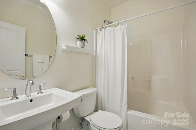 bathroom with toilet, shower / bathtub combination with curtain, and a sink