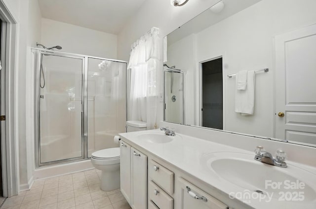 full bathroom with toilet, a sink, and a stall shower