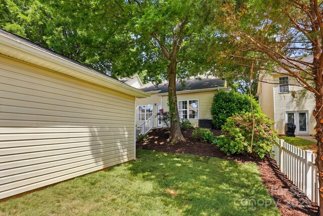 view of yard with fence and central AC unit