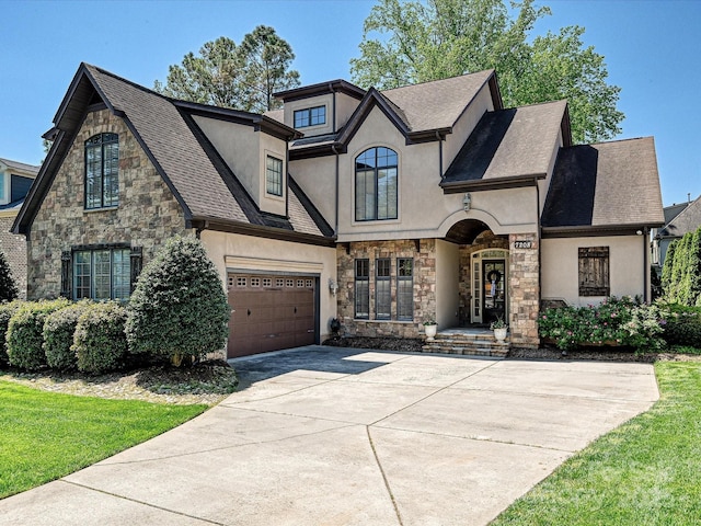 view of front facade featuring stone siding, stucco siding, driveway, and an attached garage