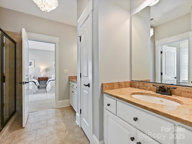 ensuite bathroom with ensuite bathroom, vanity, an inviting chandelier, tile patterned flooring, and a shower stall