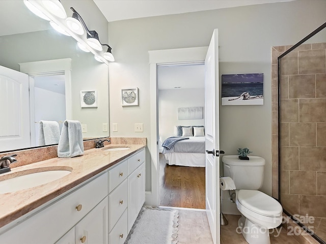 bathroom featuring double vanity, toilet, connected bathroom, and a sink