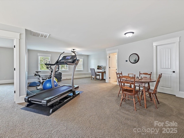 exercise area with baseboards, visible vents, and carpet