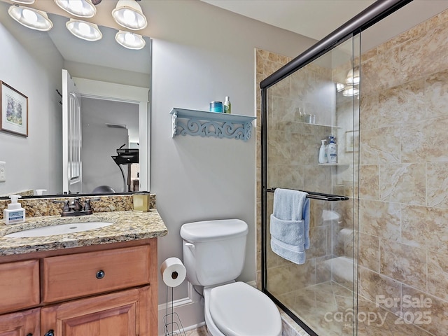 bathroom featuring a stall shower, vanity, and toilet