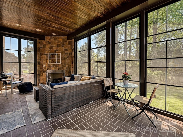 sunroom / solarium with an outdoor living space with a fireplace and plenty of natural light