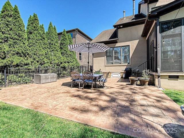 view of patio with fence and outdoor dining space
