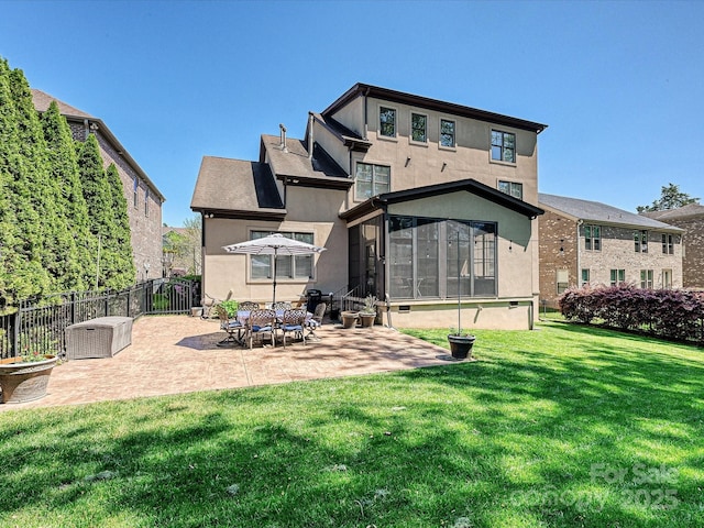 back of house with a lawn, fence, a patio area, stucco siding, and a sunroom