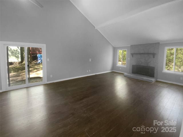 8000 Briardale Dr, Charlotte, NC 28212 - unfurnished living room with a stone fireplace, baseboards, high vaulted ceiling, and dark wood-style floors