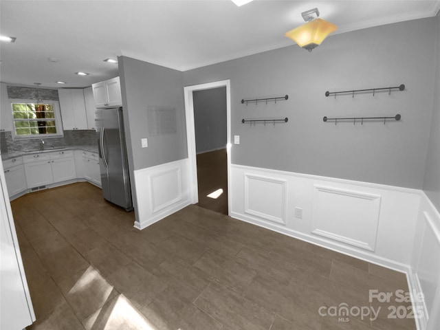8000 Briardale Dr, Charlotte, NC 28212 - interior space with white cabinets, a decorative wall, freestanding refrigerator, and a wainscoted wall