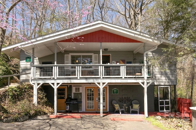rear view of property featuring french doors, a patio area, and a balcony