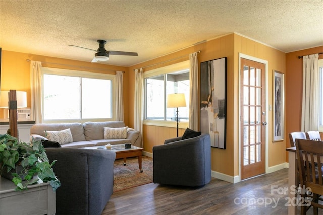 living room with cooling unit, a textured ceiling, a ceiling fan, baseboards, and wood finished floors