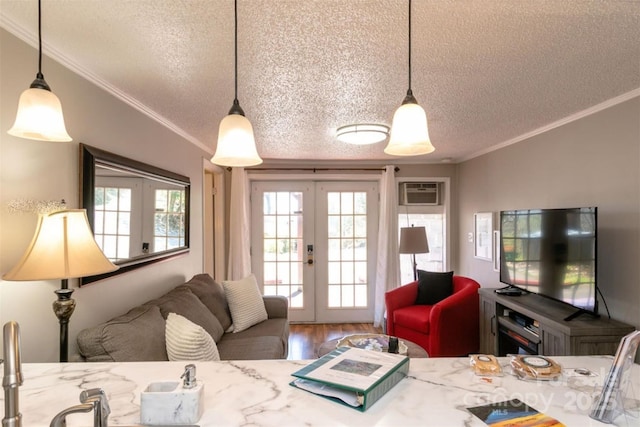 living room featuring french doors, a textured ceiling, wood finished floors, an AC wall unit, and ornamental molding