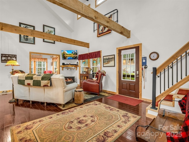120 Ashley Ct, Mill Spring, NC 28756 - living room featuring baseboards, a warm lit fireplace, stairway, wood-type flooring, and high vaulted ceiling