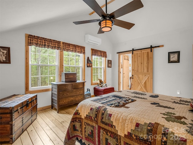 120 Ashley Ct, Mill Spring, NC 28756 - bedroom featuring a barn door, a ceiling fan, a wall mounted AC, light wood-style flooring, and lofted ceiling