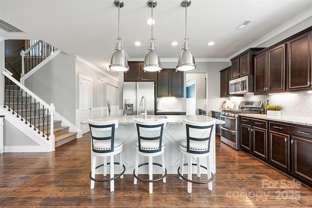 kitchen featuring appliances with stainless steel finishes, ornamental molding, decorative backsplash, and visible vents