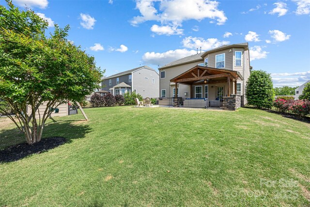 rear view of house featuring a lawn, ceiling fan, an outdoor hangout area, and a patio area