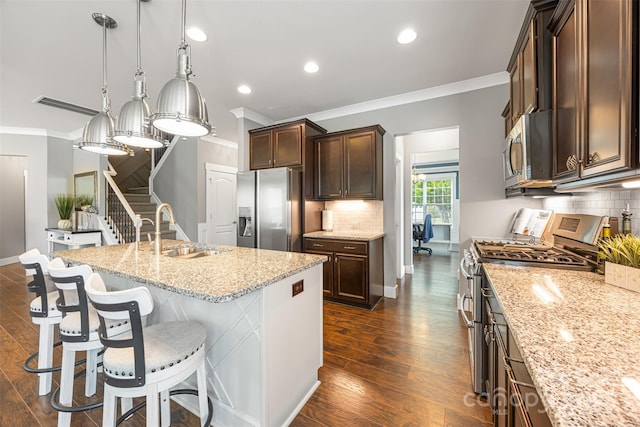 kitchen with ornamental molding, tasteful backsplash, light stone counters, a sink, and appliances with stainless steel finishes