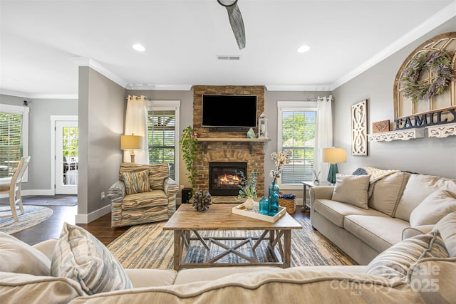 living area with ornamental molding, a healthy amount of sunlight, and wood finished floors