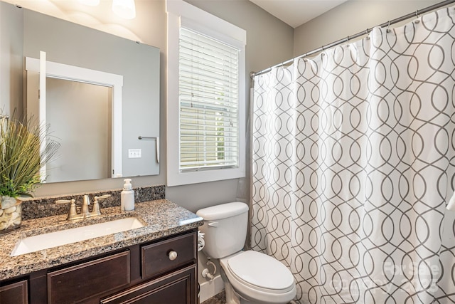 full bathroom with toilet, a shower with curtain, a wealth of natural light, and vanity