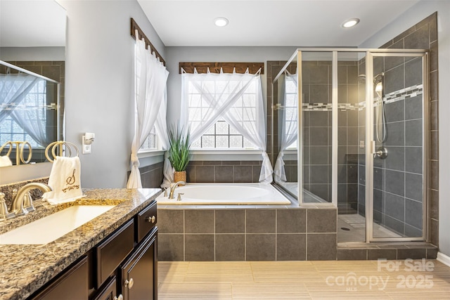 bathroom featuring recessed lighting, a garden tub, a stall shower, and vanity
