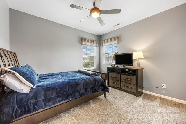 bedroom with visible vents, a ceiling fan, baseboards, and light colored carpet