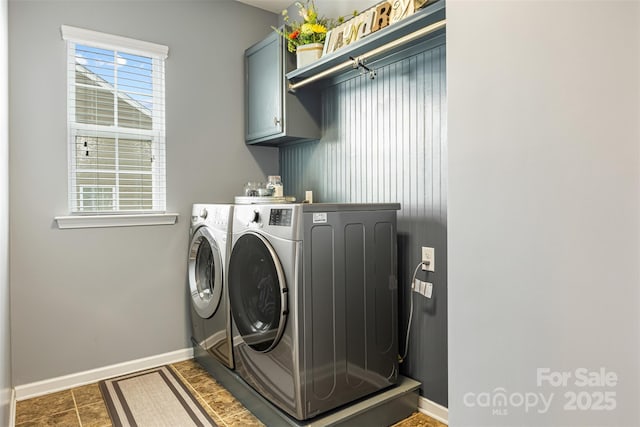 laundry area with baseboards, washer and clothes dryer, and cabinet space