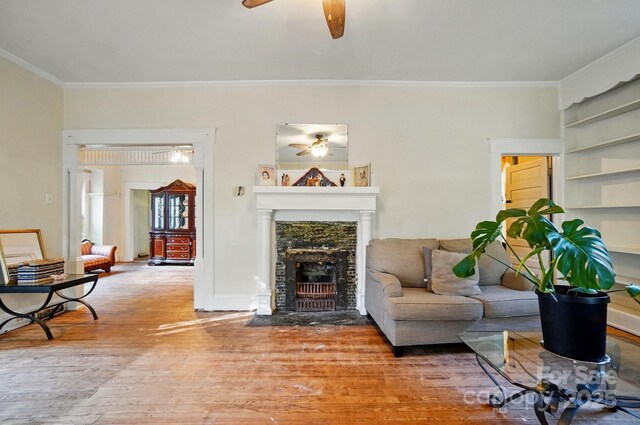 247 W Park Ave, Charlotte, NC 28203 - living room featuring a fireplace with flush hearth, light wood-type flooring, ornamental molding, and ceiling fan