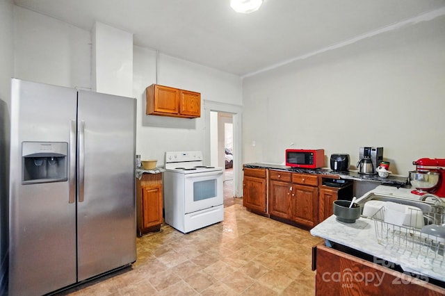 247 W Park Ave, Charlotte, NC 28203 - kitchen with stainless steel fridge, a sink, light countertops, white electric stove, and brown cabinets